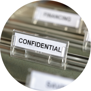 Inside of a filing cabinet with green folders and focus on confidential label.