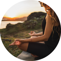 Woman meditating ooutdoors in morning.