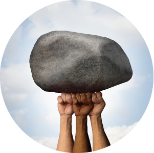 Conceptual photo of three fists holding up a rock.